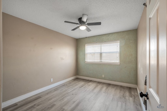 unfurnished room with a textured ceiling, ceiling fan, wood finished floors, and baseboards