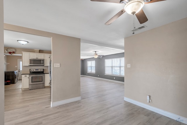 living area featuring light wood-style floors, baseboards, visible vents, and ceiling fan