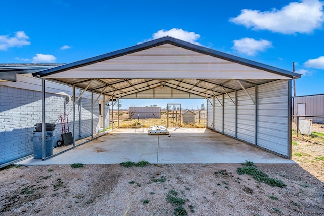 view of parking / parking lot with a carport, driveway, and fence