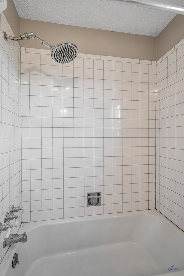 full bath featuring shower / washtub combination and a textured ceiling