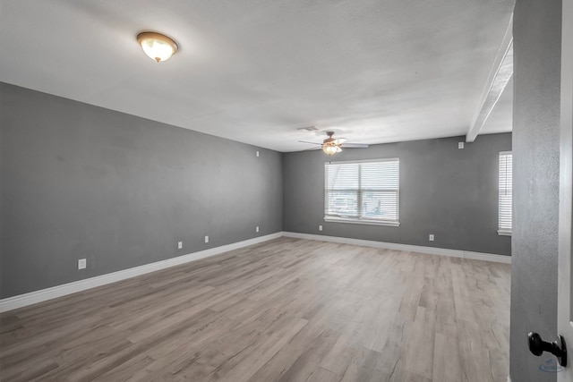 unfurnished room with light wood finished floors, plenty of natural light, baseboards, and a ceiling fan