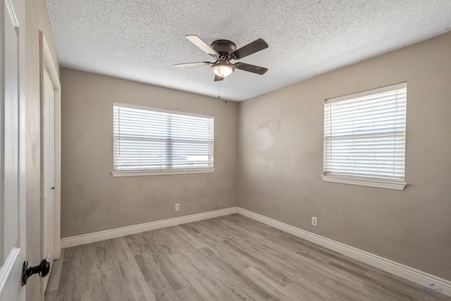 unfurnished room featuring ceiling fan, a textured ceiling, baseboards, and wood finished floors