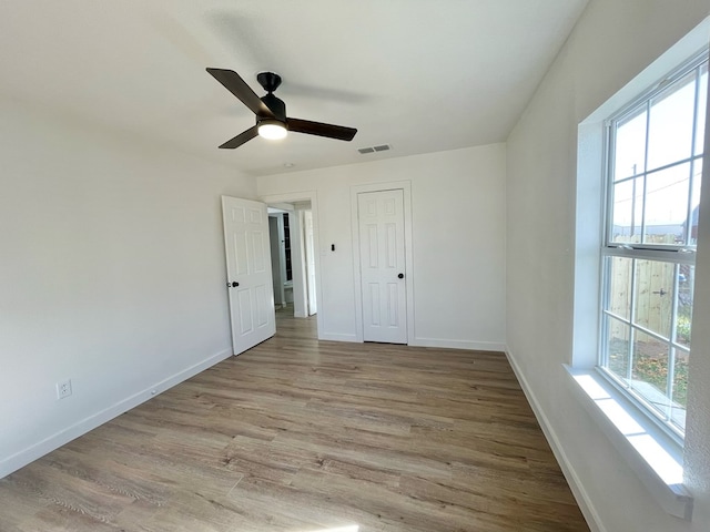 unfurnished bedroom featuring ceiling fan, a closet, and light wood-type flooring