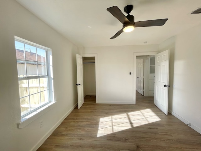 unfurnished bedroom with ceiling fan, a closet, and light hardwood / wood-style floors