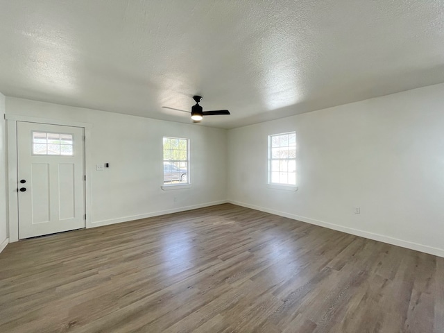 foyer entrance with ceiling fan, hardwood / wood-style floors, and a textured ceiling