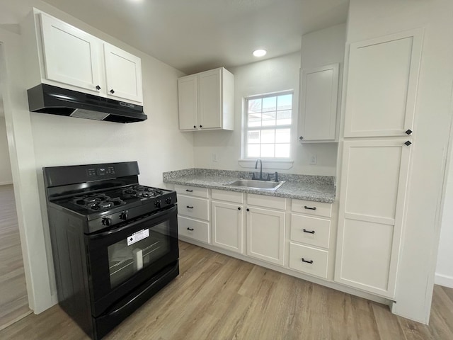 kitchen featuring black gas range, sink, white cabinets, and light hardwood / wood-style floors