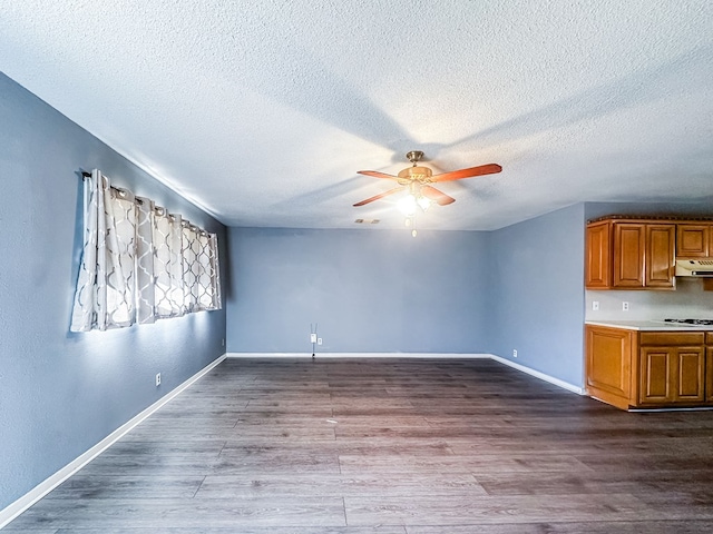 unfurnished living room with dark wood finished floors, visible vents, a ceiling fan, a textured ceiling, and baseboards