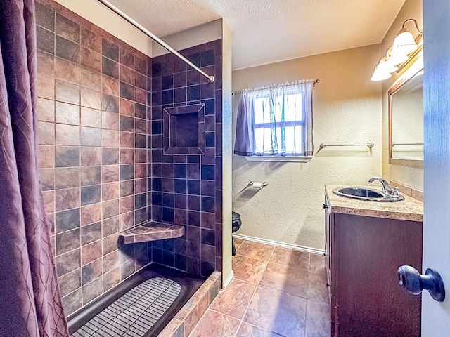 full bathroom with a textured ceiling, a textured wall, tiled shower, and vanity