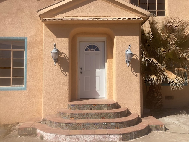 entrance to property with stucco siding