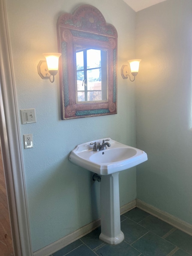 bathroom with a sink, baseboards, and tile patterned floors