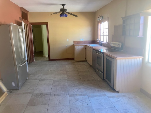 kitchen featuring ceiling fan, electric range, a sink, light countertops, and freestanding refrigerator