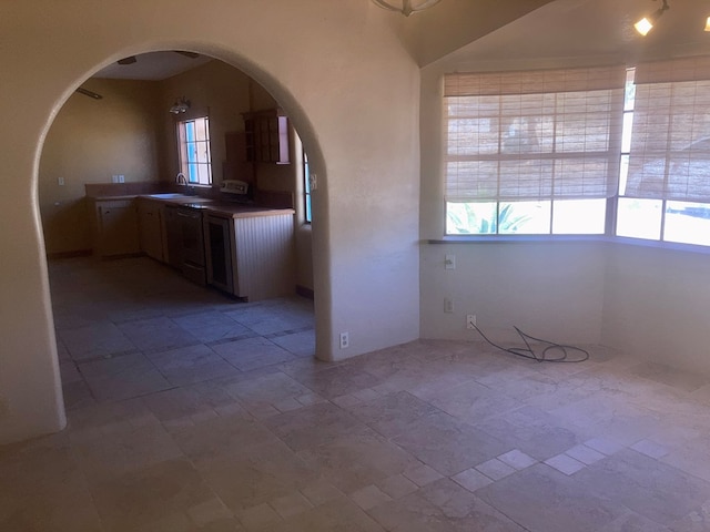 interior space with stone finish flooring, arched walkways, and a sink