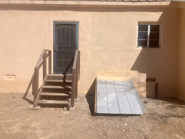 exterior space featuring a bulkhead entry and stucco siding