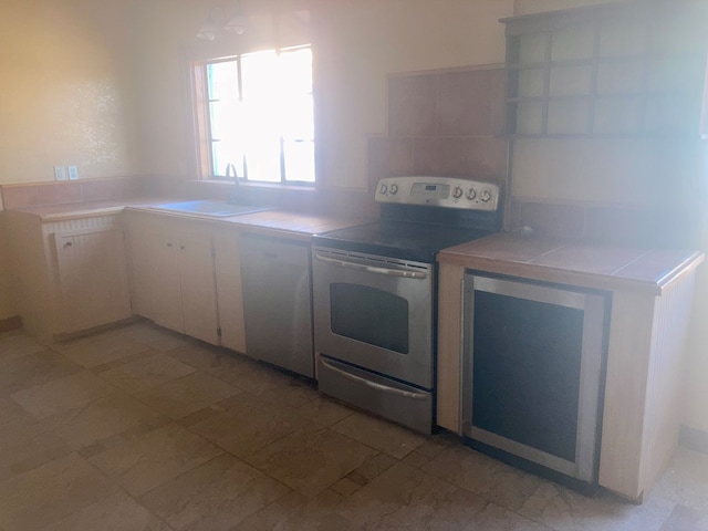 kitchen with a sink, electric range, and tile countertops