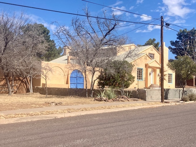 pueblo revival-style home with stucco siding