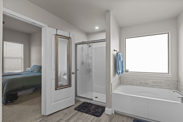 bathroom featuring shower with separate bathtub