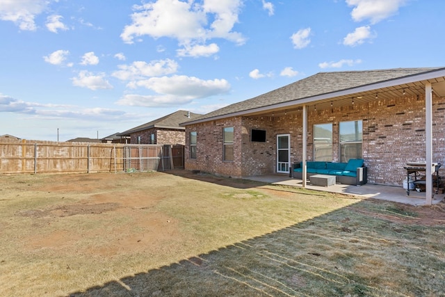 rear view of property with a lawn, an outdoor living space, and a patio