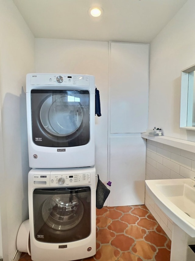 laundry area featuring tile patterned floors and stacked washer / drying machine