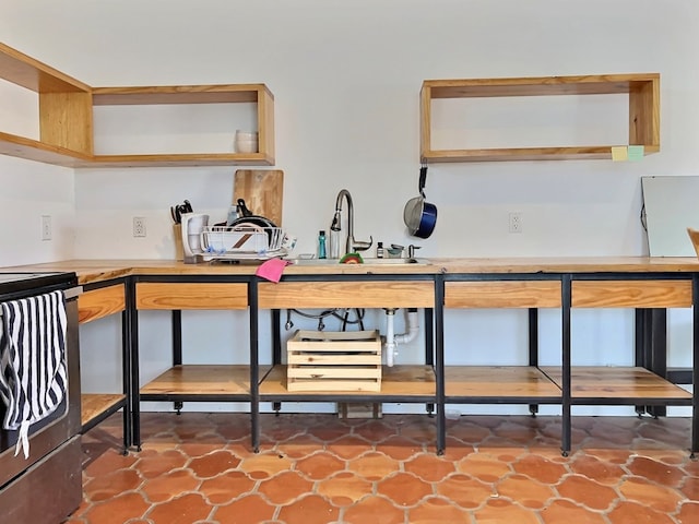 interior space featuring tile patterned flooring, range, and sink