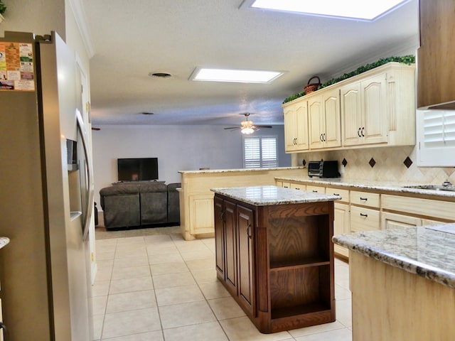 kitchen featuring stainless steel fridge, a center island, light tile patterned flooring, and decorative backsplash