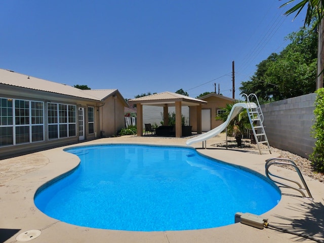 view of swimming pool with a gazebo, a water slide, and a patio