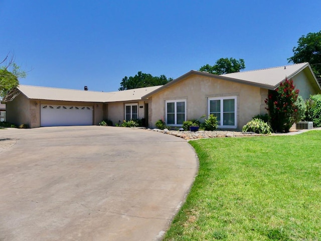 ranch-style home with concrete driveway, a front lawn, an attached garage, and stucco siding