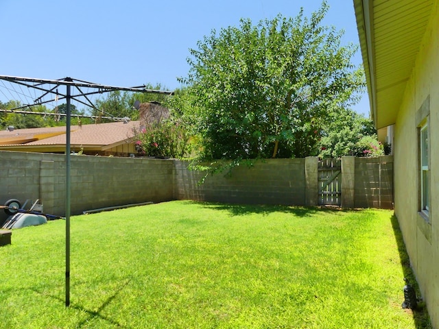 view of yard with a fenced backyard and a gate