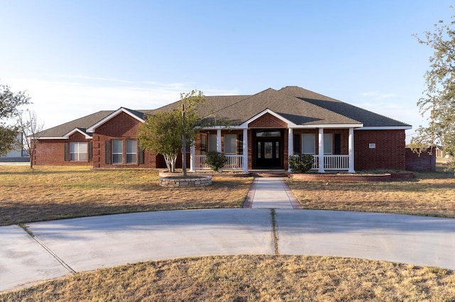 view of front facade with a front yard and covered porch