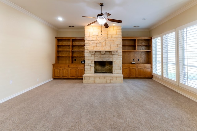 unfurnished living room featuring crown molding, light colored carpet, a stone fireplace, and ceiling fan