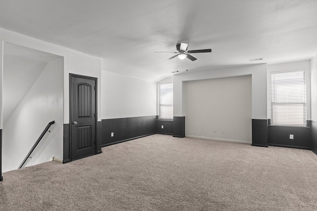 spare room featuring carpet flooring, a textured ceiling, vaulted ceiling, and ceiling fan