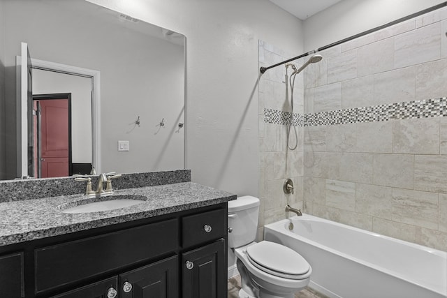 full bathroom with vanity, tiled shower / bath combo, and toilet