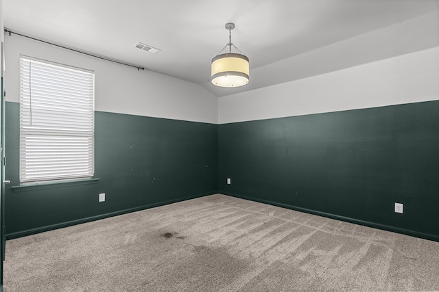 carpeted spare room with lofted ceiling