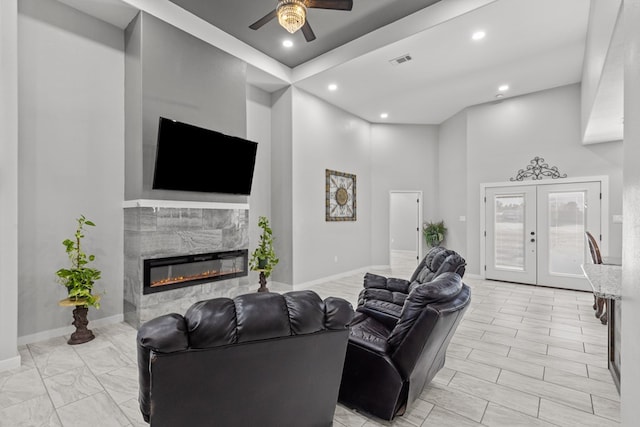 living room with baseboards, visible vents, french doors, and a high end fireplace