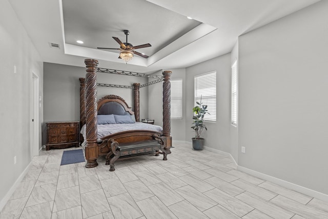 bedroom featuring a tray ceiling, recessed lighting, visible vents, a ceiling fan, and baseboards