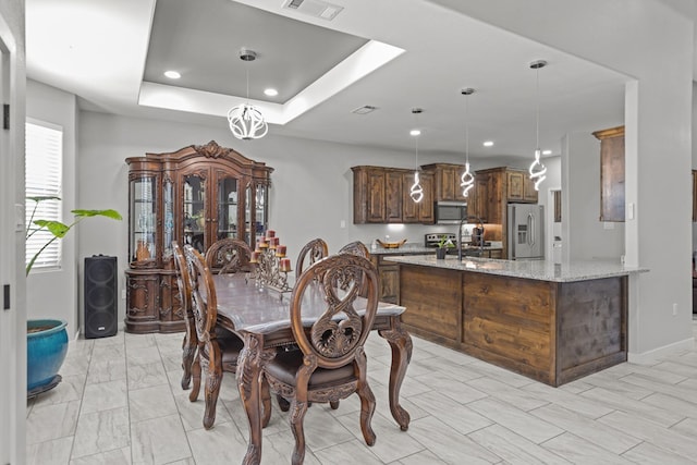 dining space with baseboards, visible vents, a raised ceiling, and recessed lighting