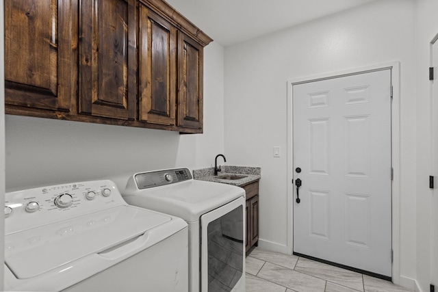 laundry room featuring baseboards, cabinet space, independent washer and dryer, and a sink