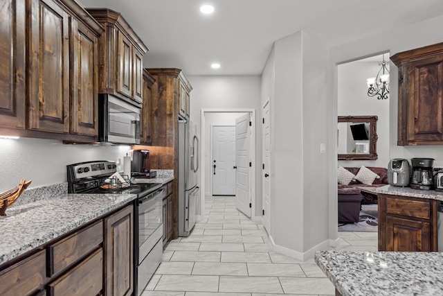 kitchen featuring dark brown cabinetry, light stone counters, stainless steel appliances, and recessed lighting