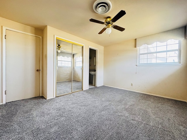 unfurnished bedroom featuring ceiling fan, two closets, and multiple windows