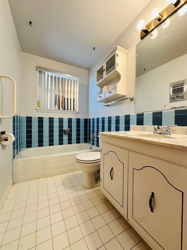 bathroom featuring tile patterned flooring, a tub, vanity, and toilet