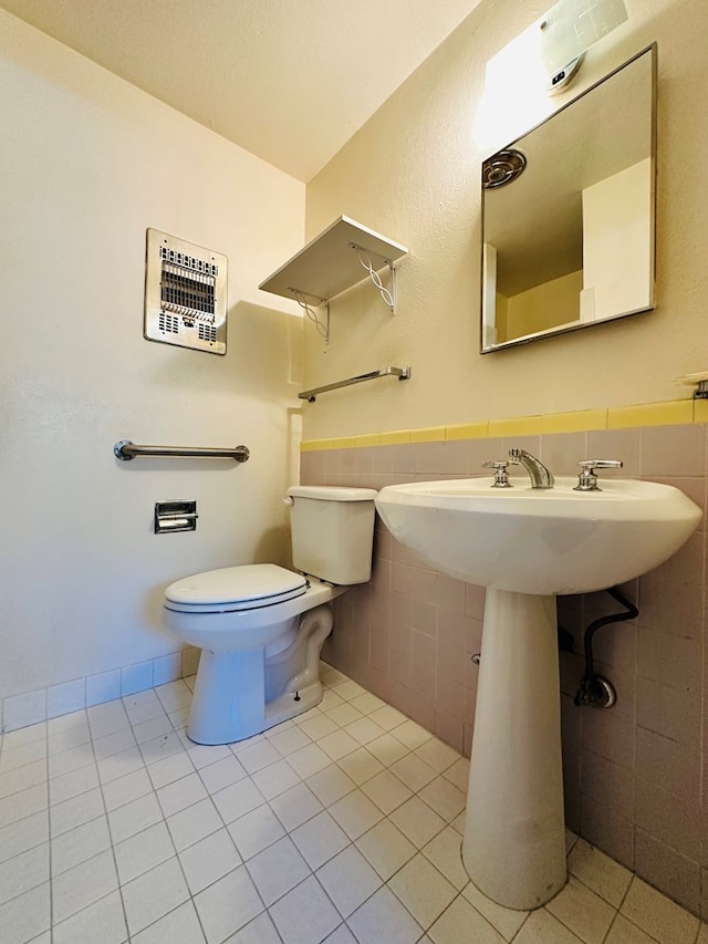 bathroom featuring toilet, tile patterned floors, tile walls, and heating unit