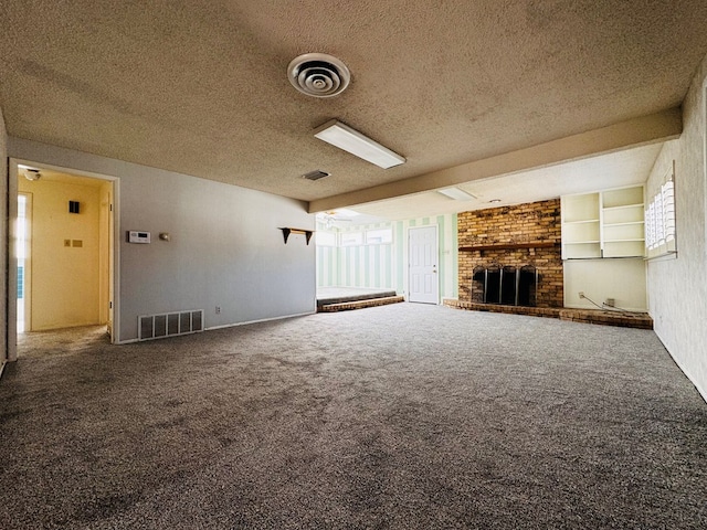 unfurnished living room with a textured ceiling, built in features, carpet, and a fireplace