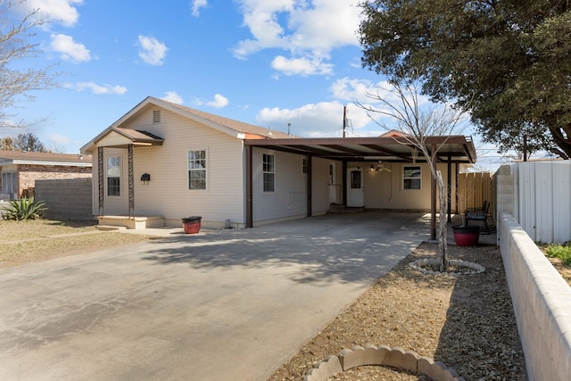 ranch-style home with a carport, fence, and concrete driveway