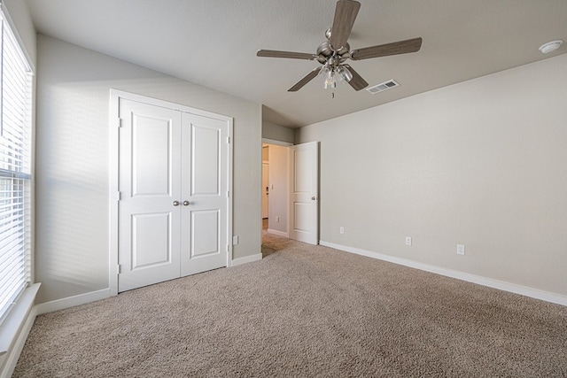 unfurnished bedroom featuring a closet, ceiling fan, and carpet floors