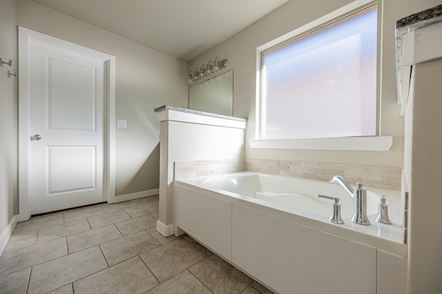 bathroom with a tub and tile patterned floors