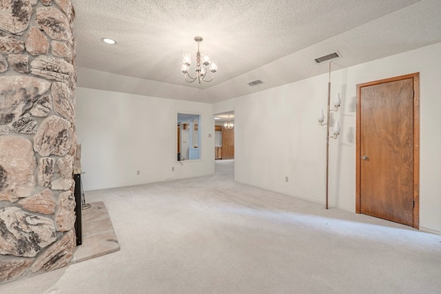 unfurnished living room featuring light carpet, a textured ceiling, and an inviting chandelier