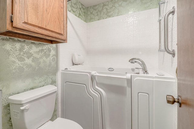 bathroom with a washtub and toilet