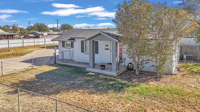 view of front of house featuring central AC unit and a front lawn