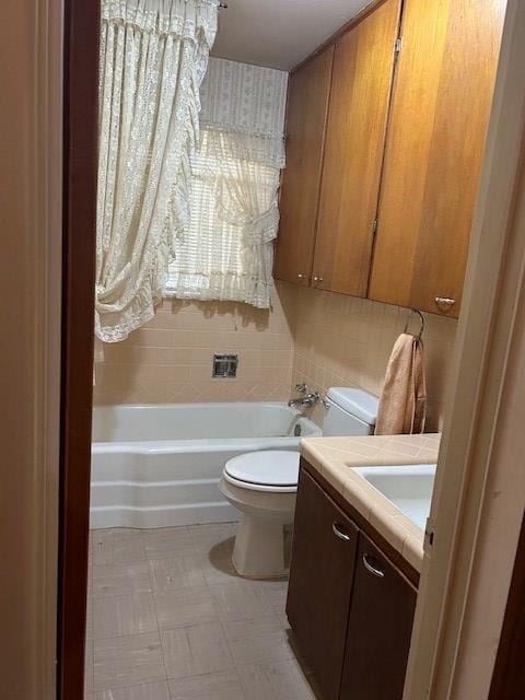 bathroom featuring a tub to relax in, vanity, and toilet