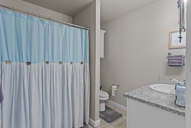 bathroom featuring vanity, tile patterned flooring, and toilet