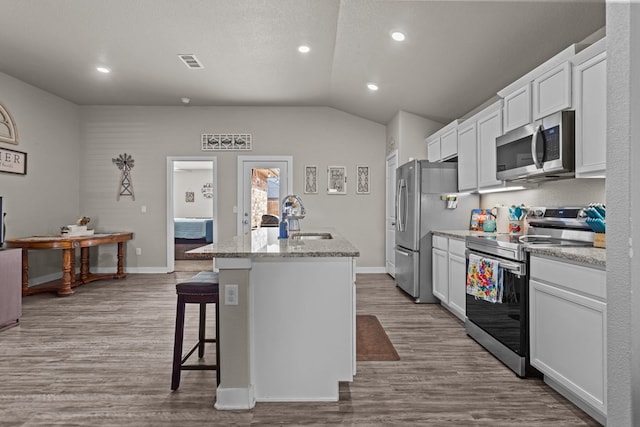 kitchen featuring stainless steel appliances, sink, a kitchen island with sink, and white cabinets